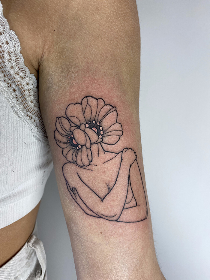 tatuaje mujer abraza flores